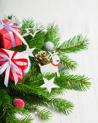 New Year and Christmas background on an white wooden background. View from above. Christmas tree branches and snow, gifts and decorations.