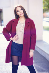 young beautiful stylish woman in claret coat, street style, spring summer trend, dark skirt, beige...