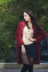 young beautiful stylish woman in claret coat, street style, spring summer trend, dark skirt, beige...