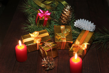 Christmas gift colored boxes, cones, Christmas tree and candles on a wooden table. Composition of celebrities. Selective focus.