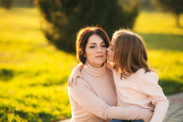 Fototapeta premium Little girl with mother walking in the park in autumn