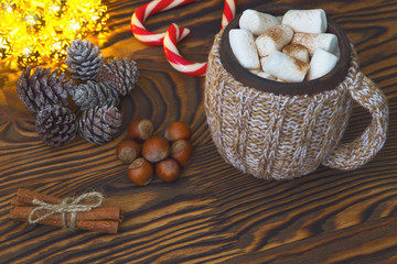 Hot chocolate with marshmallows, candy, spices and nuts on grunge dark table. Christmad card