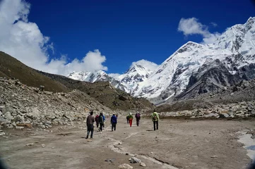 Poster Туристы идут по долине на фоне гор. © papava