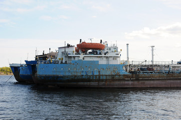 The old barge ship is anchored at an abandoned shipyard, in the harbor