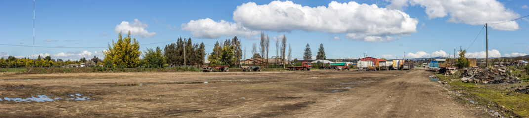Fototapeta na wymiar Multiple trucks park in a large parking lot.