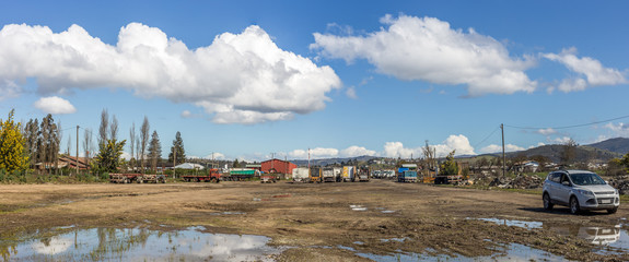 Multiple trucks park in a large parking lot.