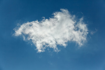 Background of transparent white clouds in a light blue sky illuminated by the setting sun.