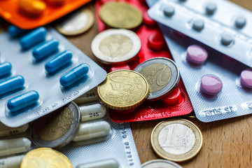 Medicine cost. Euro coins among the pills
