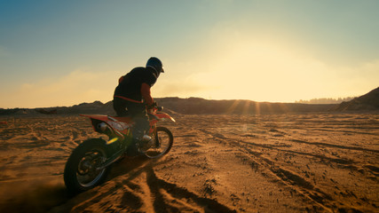 Shot of the Professional Motocross Driver Riding on His FMX Motorcycle on the Extreme Off-Road Terrain Track.