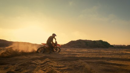 Shot of the Professional Motocross Driver Turning on His FMX Motorcycle on the Extreme Off-Road Terrain Track.