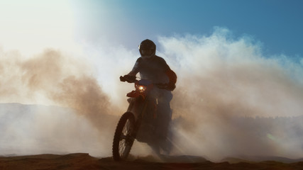 Professional Motocross Motorcycle Rider Drives Through Smoke and Mist Over the Dirt Road Track.