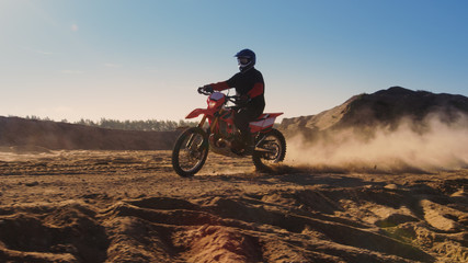Side View Footage of the Professional Motocross Motorcycle Rider Driving on the Dune and Further...