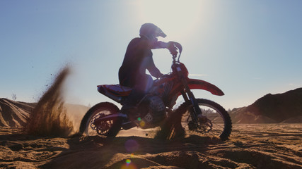 Fototapeta na wymiar Professional Motocross FMX Motorcycle Rider Drives in Circles on the Off-Road Deserted Quarry.