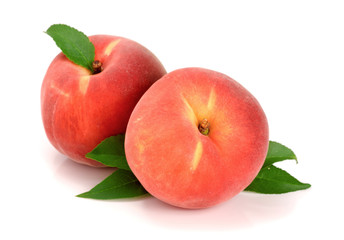 Two peaches with green leaf isolated on white background