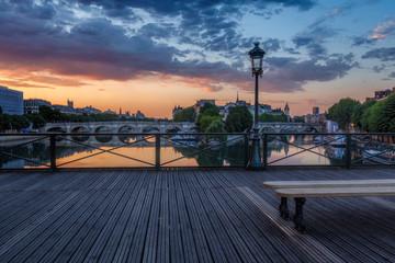 Fototapeta na wymiar Sunrise over Paris, France with Pont des Arts and the river Seine. Colourful skyline with dramatic clouds.