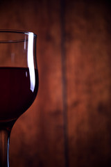 A glass of red wine on an old wooden background