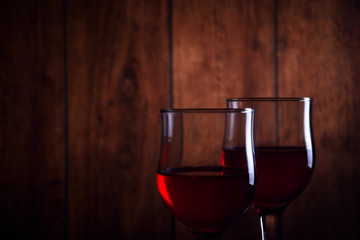 A glass of red wine on an old wooden background