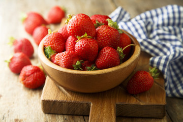 Fresh strawberry in rustic wooden bowl