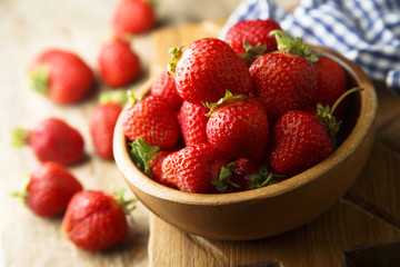 Fresh strawberry in rustic wooden bowl
