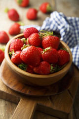 Fresh strawberry in rustic wooden bowl