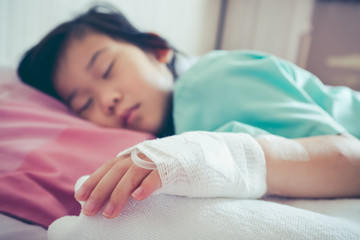 Obraz na płótnie Canvas Illness asian child admitted in hospital with saline intravenous on hand.