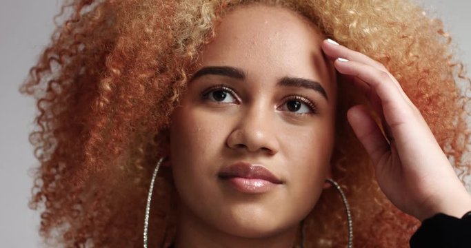 Portrait of a strong confident mixed race woman with reddish blond afro and large hoop earrings