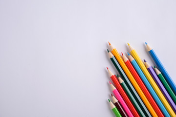 Colored crayons background. Many different colored pencils on white background