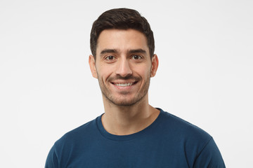 Fototapeta na wymiar Close up portrait of smiling handsome guy in blue t-shirt isolated on gray background