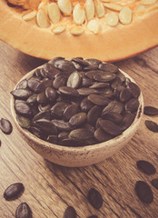 Pumpkin seeds on a wooden background.