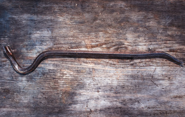 Old curve of the nail puller on a wooden background