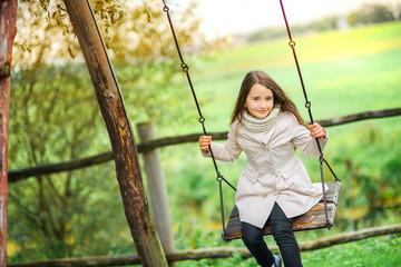 beautiful girl riding on a swing.