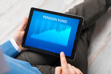 Man looking at pension fund performance graph on tablet computer.