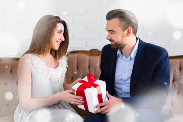 christmas or valentine's day concept - handsome man giving gift box to his girlfriend