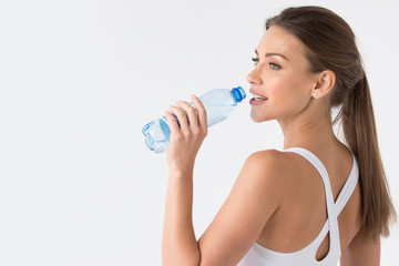 Woman drinking water from blue bottle