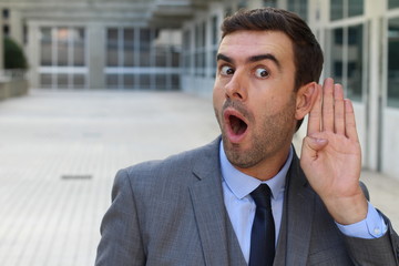 Businessman trying to hear a gossip