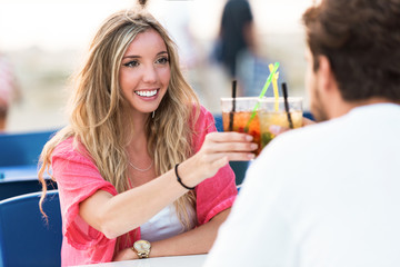 Beautiful young couple drinking refreshment on the beach.