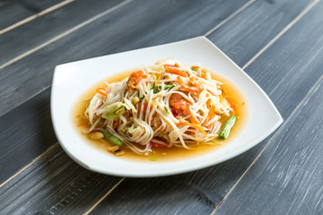 papaya salad on wood table, Thai cuisine, Som Tam Malakor