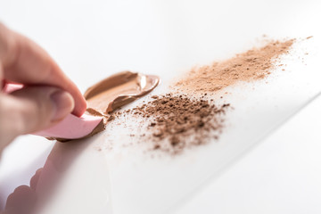 Hand mixt verschiedene Make Up Foundations und Puder Farben mit Schwamm