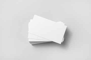 Photo of blank business cards with soft shadows on paper background. Template for ID. Mock up for branding identity. Top view.