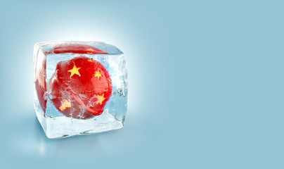 Beautiful red Christmas ball inside ice cube.