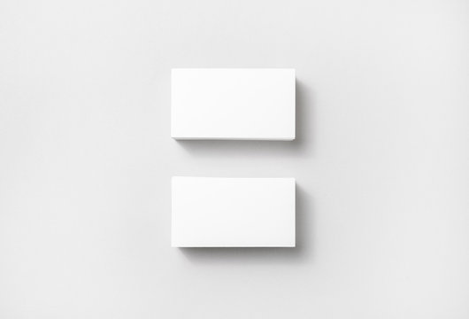 Blank white business cards on paper background. Mockup for branding identity. Template for graphic designers portfolios. Top view.