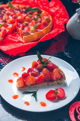 Strawberry pie on white plate black wooden table. One piece.  Romantic. Love. Heart. Toned photo. Valentine Day