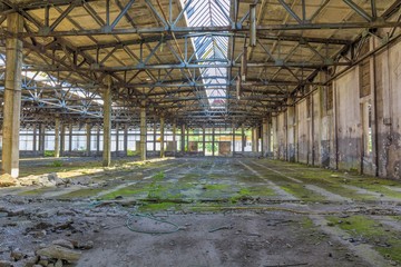 Abandoned large factory industrial interior. Inside the ruins of an old factory  in Romania of a Communist Era. Step inside of abandoned old factory in eastern Europe.