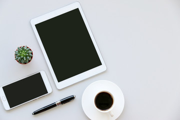 digital tablet White wooden table with office supplies smartphone,pen,cactus and Morning coffee workplace with text space,top view