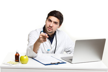 handsome doctor man in his office at the desk, looking at the lens