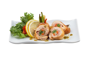 Isolated Stir fried chicken wrap with carrot. scallion and radish served with sliced lemon, tomato and lettuce in white ceramic plate on washi (Japanese paper).