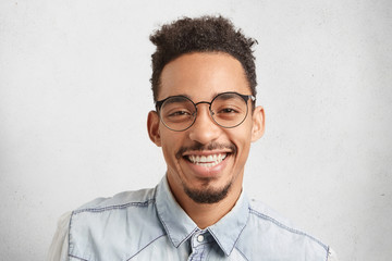 Horizontal portrait of happy male enterpreneur being glad to succeed in marketing development, expresses positive emotions and feelings, isolated over white studio background. Facial expressions