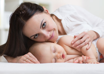 Obraz na płótnie Canvas Close shot of a mother touching her sleeping newborn baby