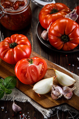 Raw tomatoes and tomato sauce in jar
