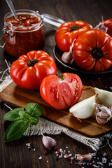 Raw tomatoes and tomato sauce in jar